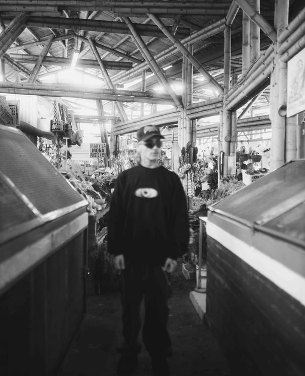 Hombre vestido de negro en plaza de mercado