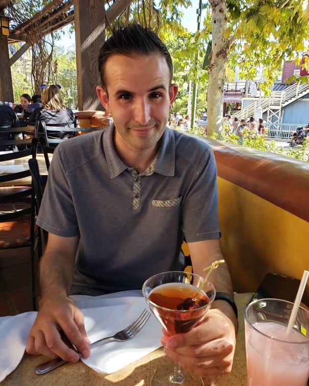 a man sitting at a table with a drink