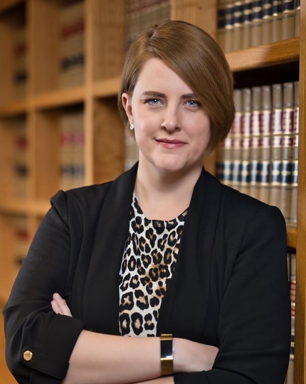 a woman in a leopard print dress and a black blazer jacket in library