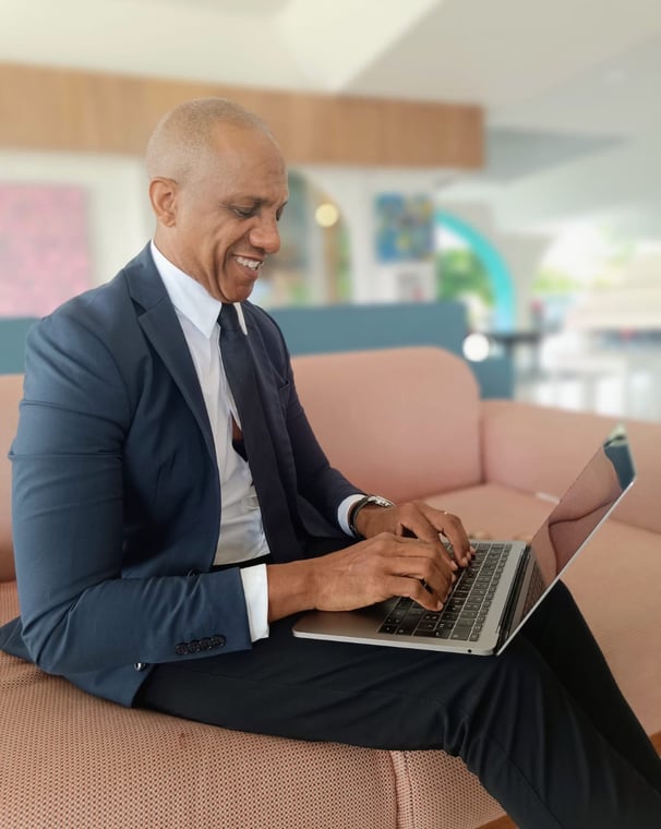 « Bruno Valery concentré sur son ordinateur dans le lobby élégant d’un hôtel 4 étoiles en Guadeloupe »