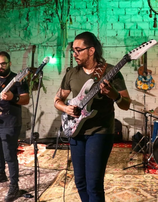 Anderson Alerrandro tocando guitarra durante a performance da Banda Onacra.