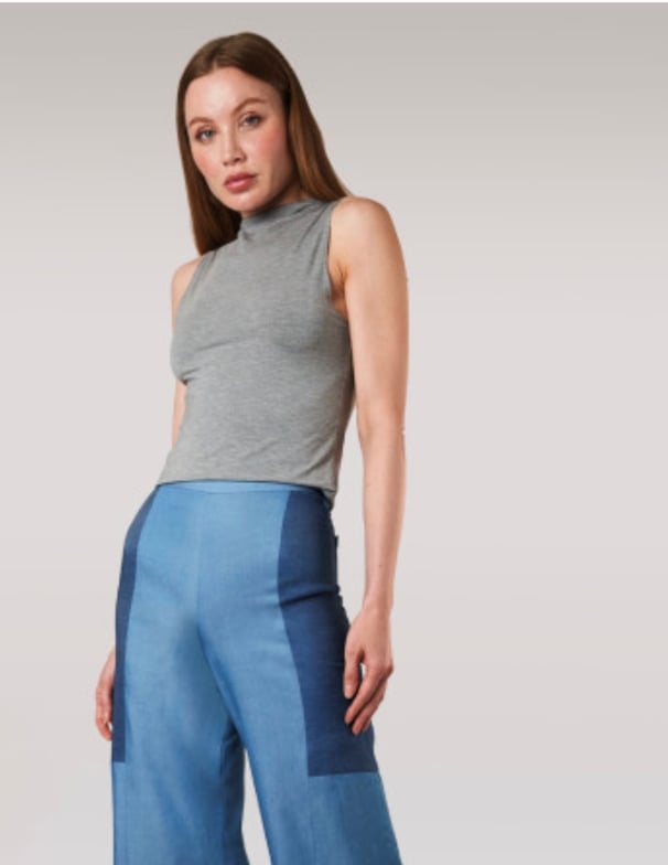 Woman wearing a grey tank top with blue pants