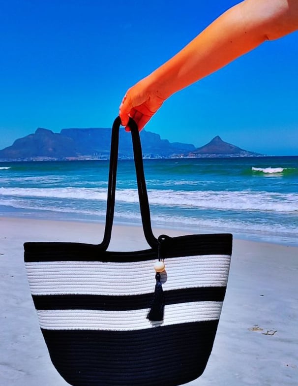 a person holding a black and white striped bag