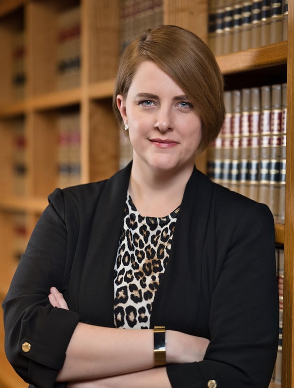 a woman in a leopard print dress and a black blazer jacket in library