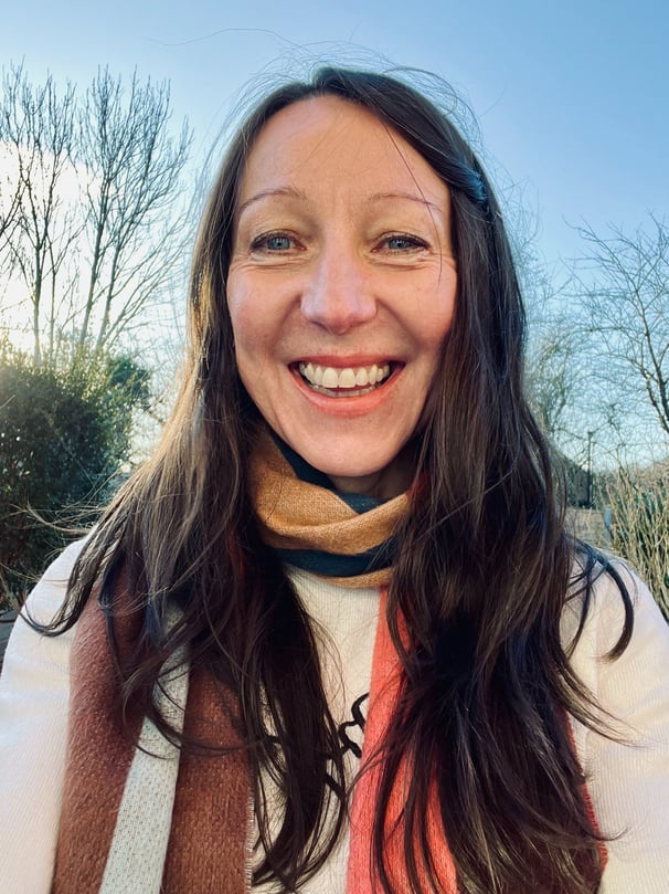 Olivia Harrison smiling with a blue sky behind her