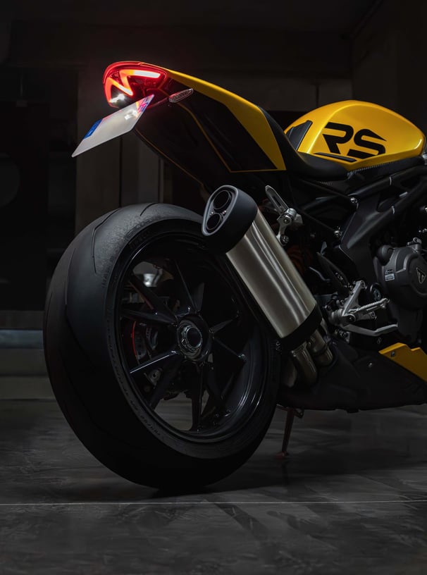 a motorcycle parked in a garage with a yellow and black motorcycle