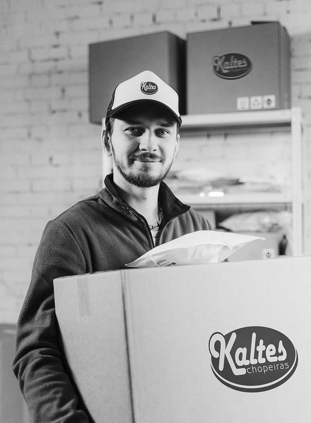 Colaborador segurando caixa de produtos da Kaltes chopeiras