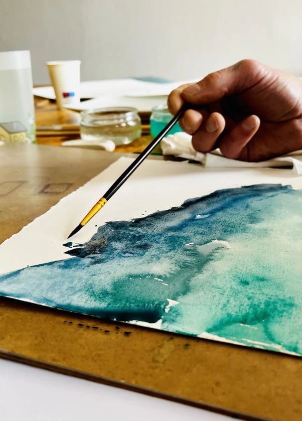 artiste qui peint un paysage à l'aquarelle