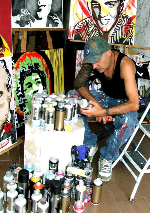 Artista Sérgio Astral pintando quadros personalizados em seu ateliê.