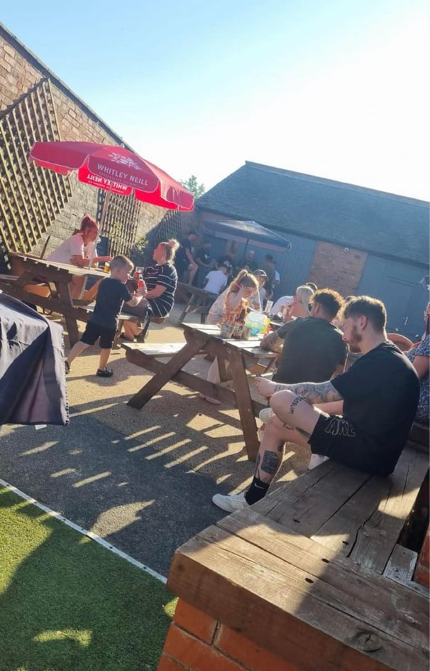 a group of people sitting in a beer garden