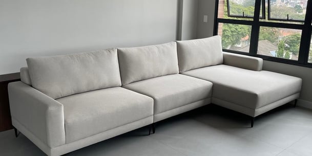 Sofá feito sob medida com chaise em tecido suede na cor cinza claro