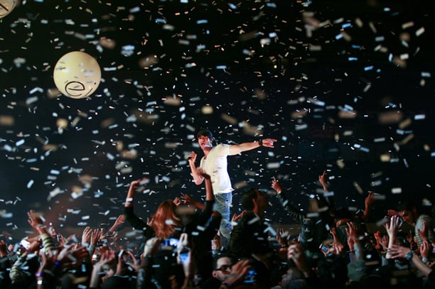 Un homme au milieu de confettis lors d’un concert.