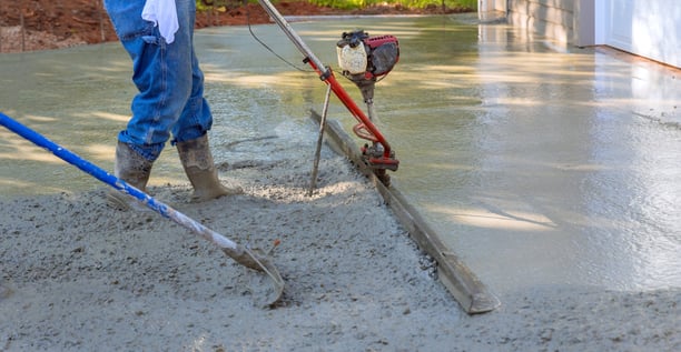 a man is using a concrete blocker to make a concrete floor