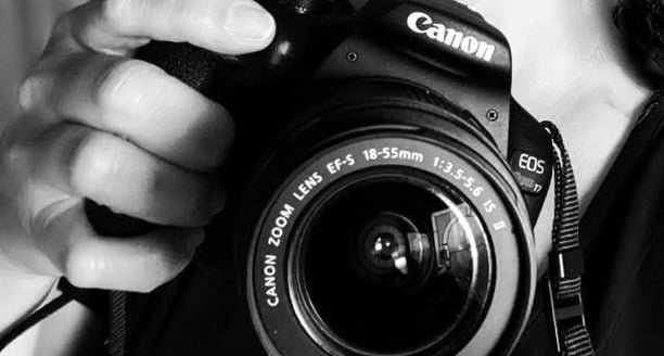 a woman taking a picture with a canon DSLR camera