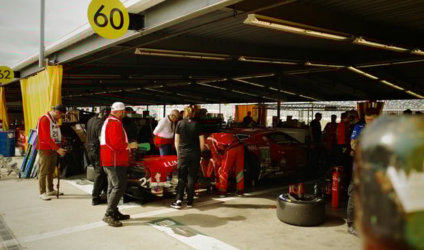 Macchina ferrari rossa nei box meccanici