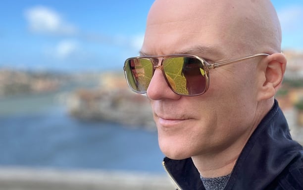 close-up of a bald man in mirror shades 