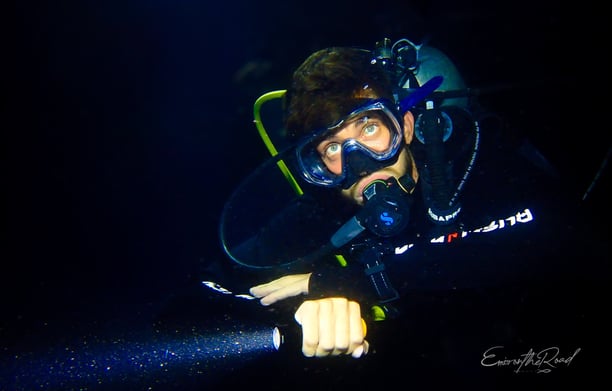 Male scuba diver with torch at ight in Gili Trawangan