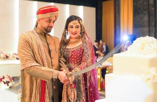 a man and woman are cutting into a wedding cake