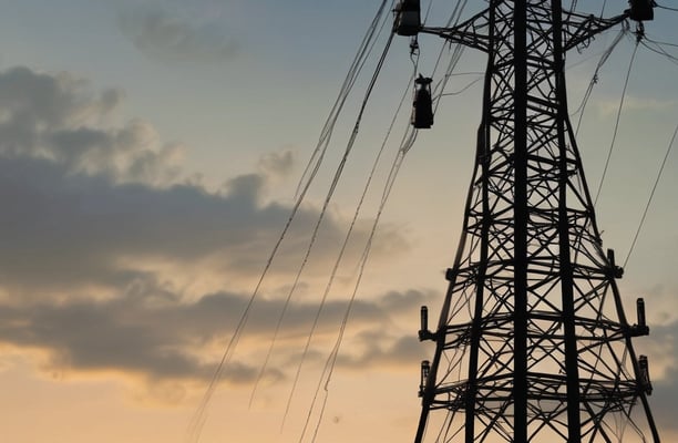 A counter with the name 'Janji Jiwa' above it, featuring a wooden panel design. Two people are behind the counter; they appear to work there. To the left, there are promotional posters, including one advertising a 10% cashback offer with GoPay. There are hanging lights and green plants adding to the decor.