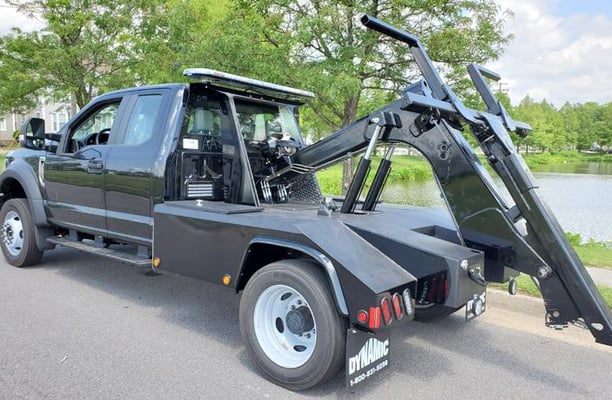 a black truck with a craned up to it's side
