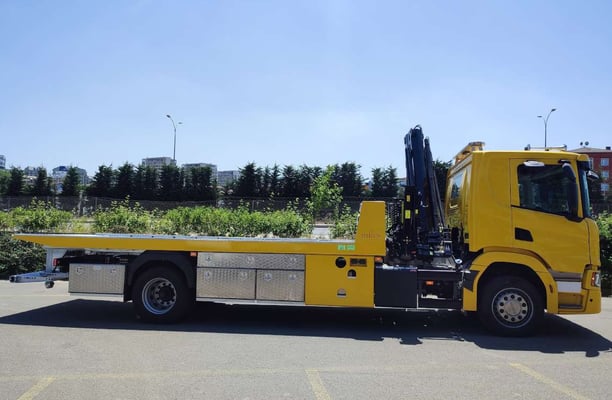 a yellow truck with a crane on it's back
