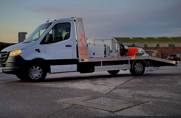 a white flat bed tow truck