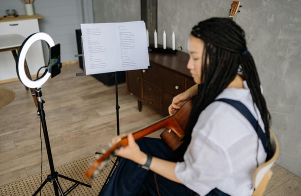 Acoustic guitar and sheet music setup for a guitar lesson