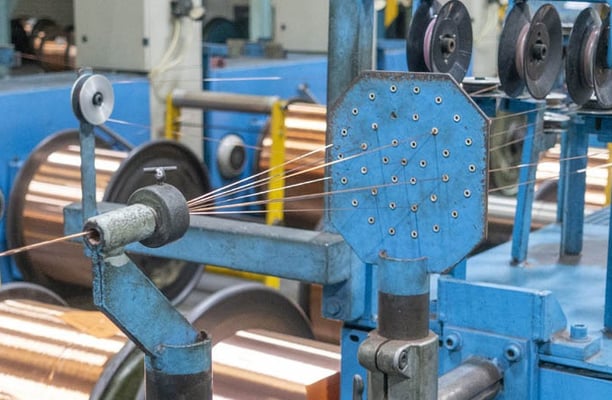 a machine is spinning a coil of copper foil