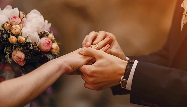 a bride and groom holding hands in a wedding ceremony