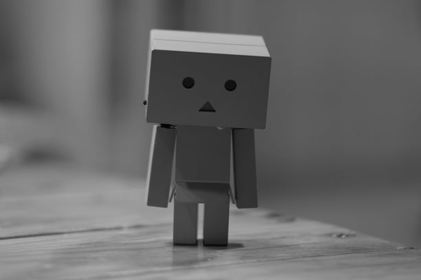 a small paper toy with a sad face