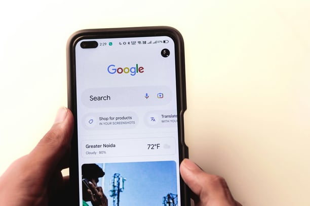 a person holding a phone with a google search