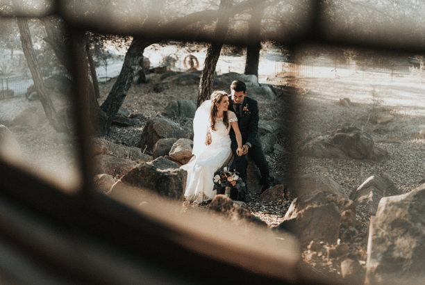 a bride and groom standing in front of a window