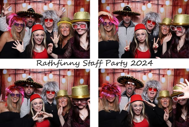 Group of people in costume wigs, hats, and glasses posing for fun photo booth pictures at corporate event by Get The Picture