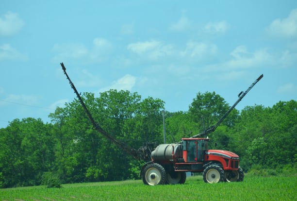 an image of a high clearance sprayer preparing to weed and feed a crop