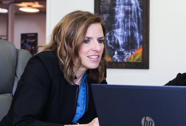 a woman sitting at a table with a laptop