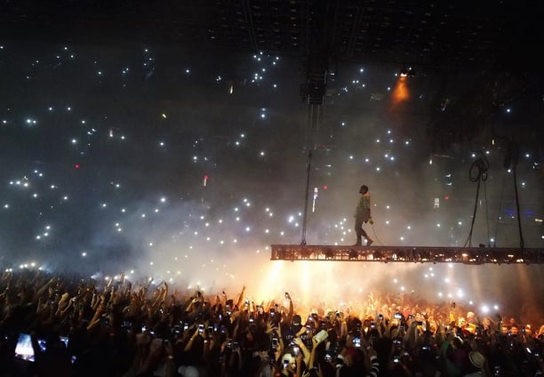 a man standing on a stage with a crowd of people