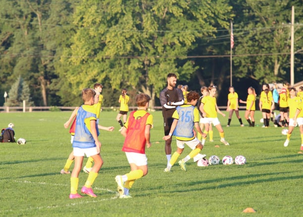 a group of young people playing soccer on a field