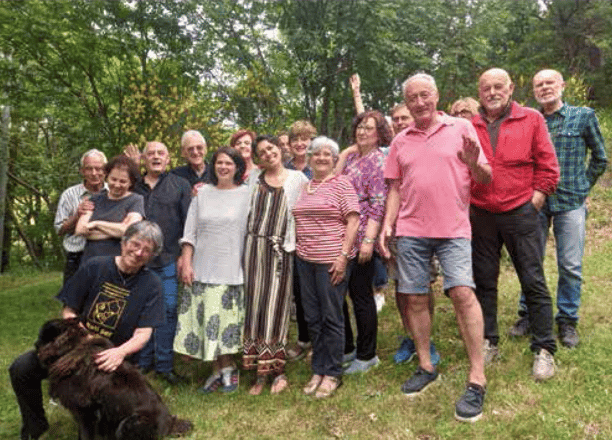 a group of people standing in a field with a dog