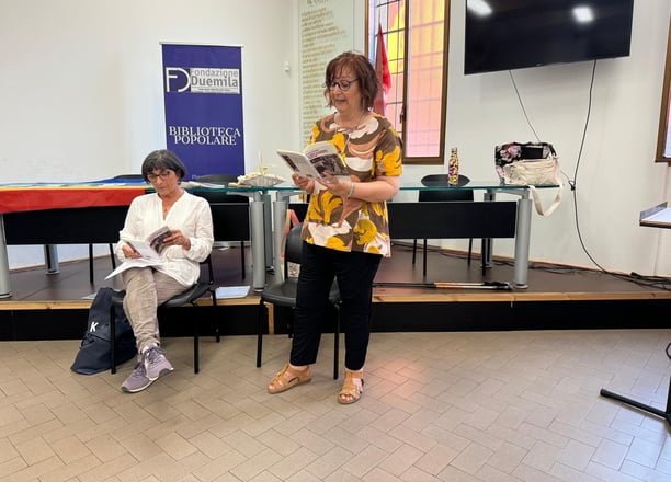 a woman in a yellow dress is reading a newspaper