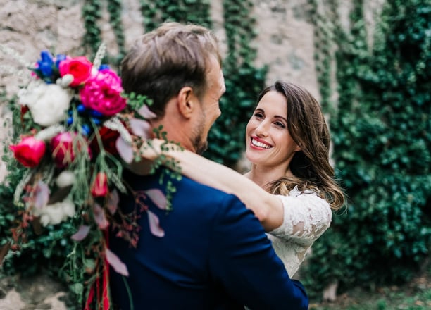 a bride and groom are smiling and hugging each other