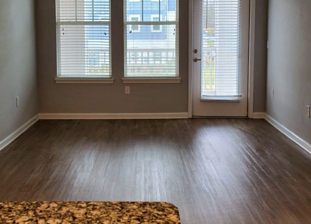 Clean and polished hardwood-style floor in a modern apartment living area.