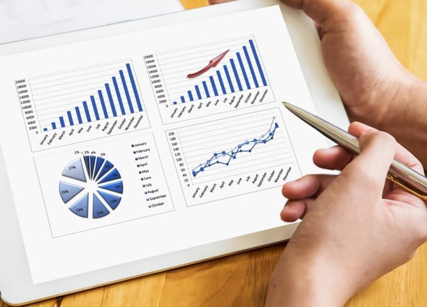 A person holding a tablet and other person is using a pen to explain the details of his investments