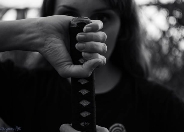 a woman holding a katana and a katana in her hand