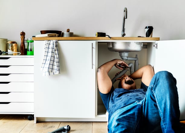 A plumber fixing a domestic kitchen sink