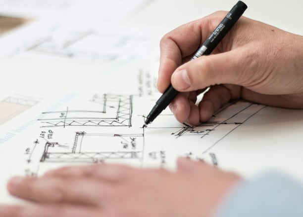 a person is holding a pen and writing on a paper