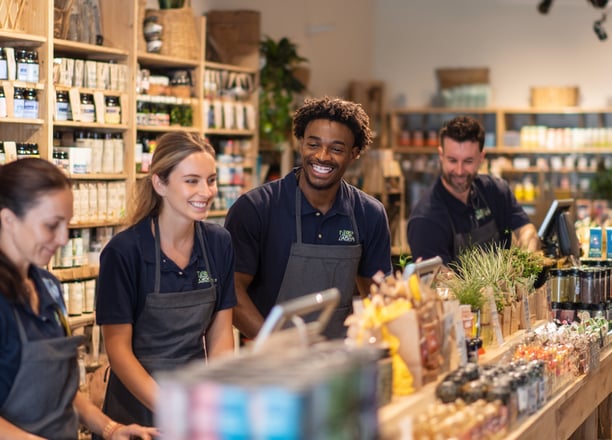 a group of people standing around a counter in a health shop