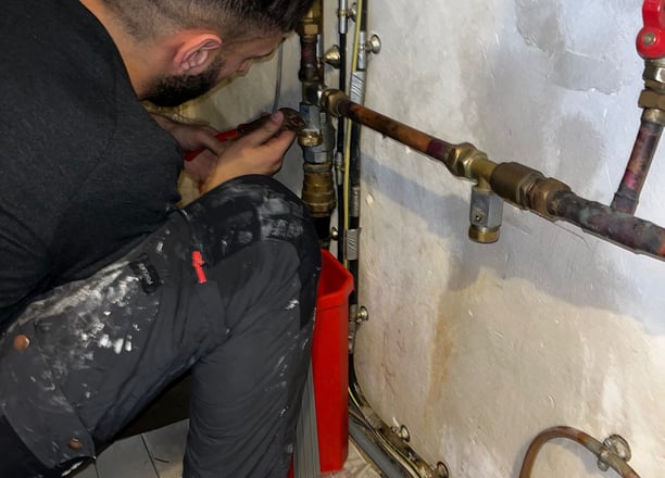 Une personne entrain de réparer une fuite d'eau