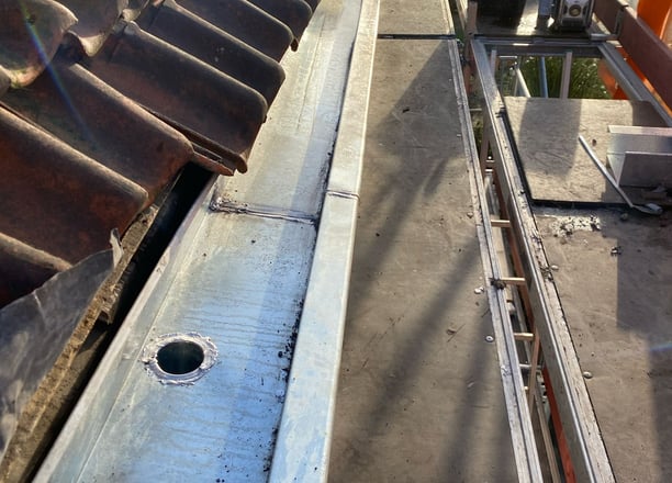 a roof top with a metal pipe and a metal pipe