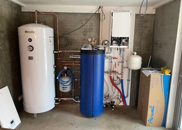 a room with a tankless water heater and a large blue tank
