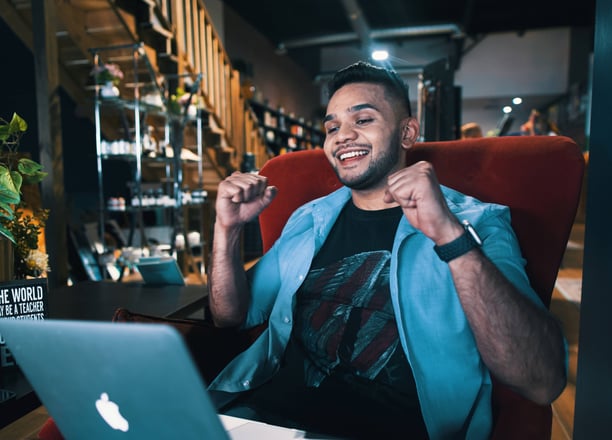 a man sitting in a chair with a laptop